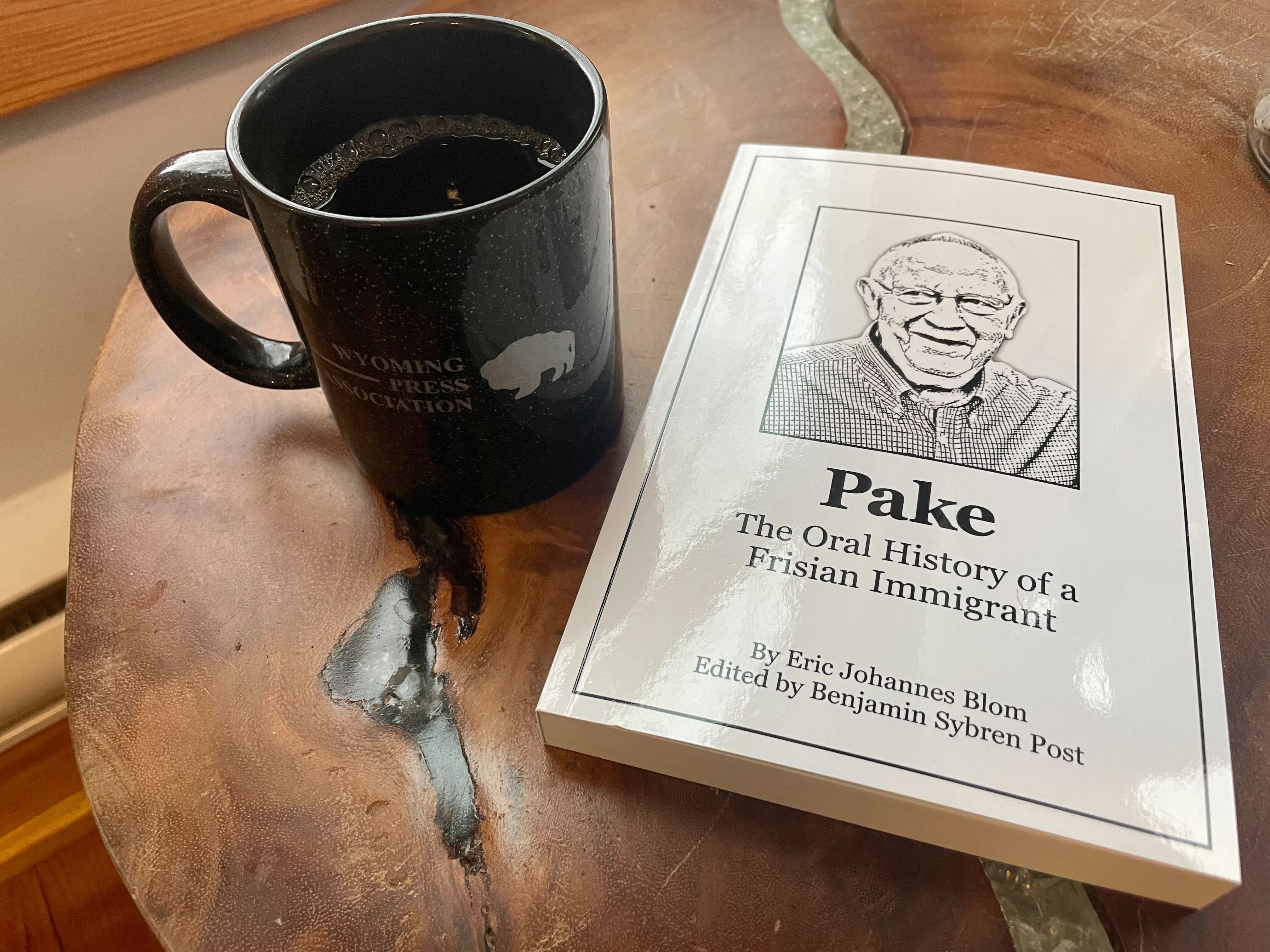 A photo of a book and a coffee mug on a table.